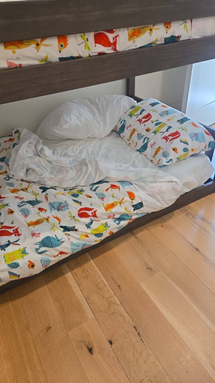 Neatly made children's bunk bed with fresh bedding after cleaning