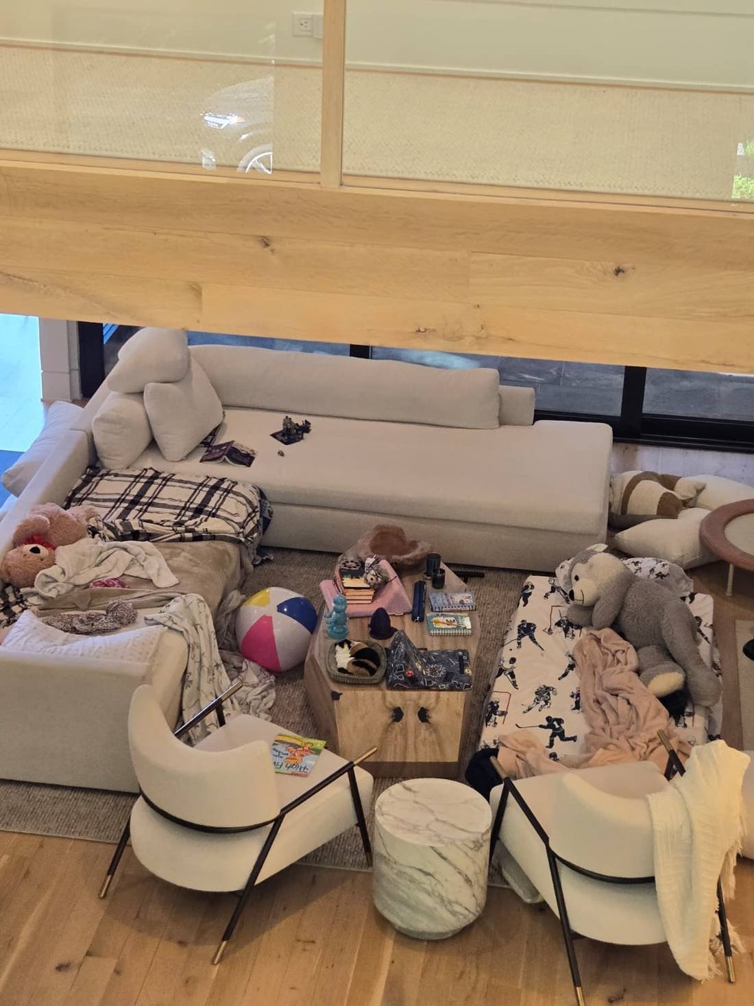 Cluttered family living room with toys, blankets and scattered items before cleaning